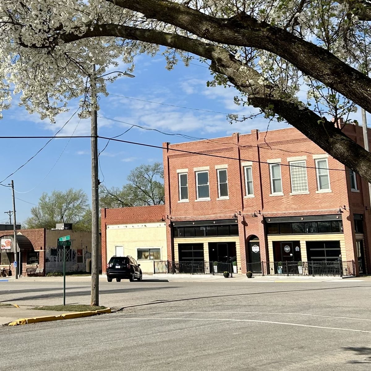 A large two story building, apartments at top and business/gathering area below.