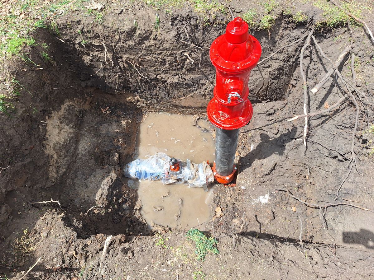 a new hydrant and valve visible at the bottom of a large hole
