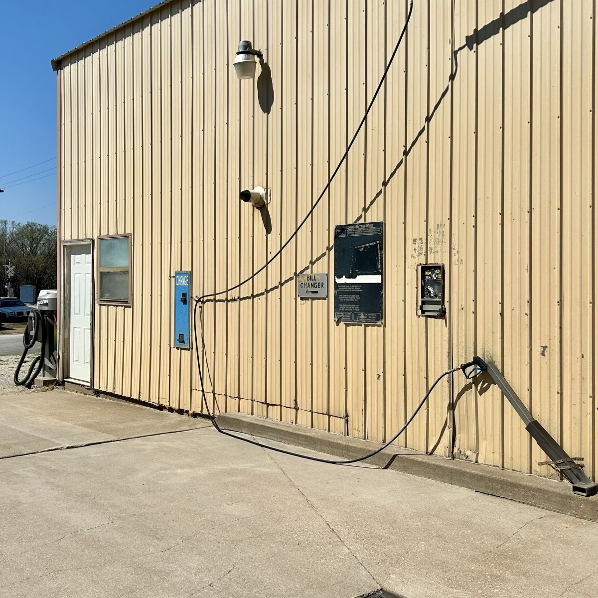 side of a metal building with an outdoor car wash area