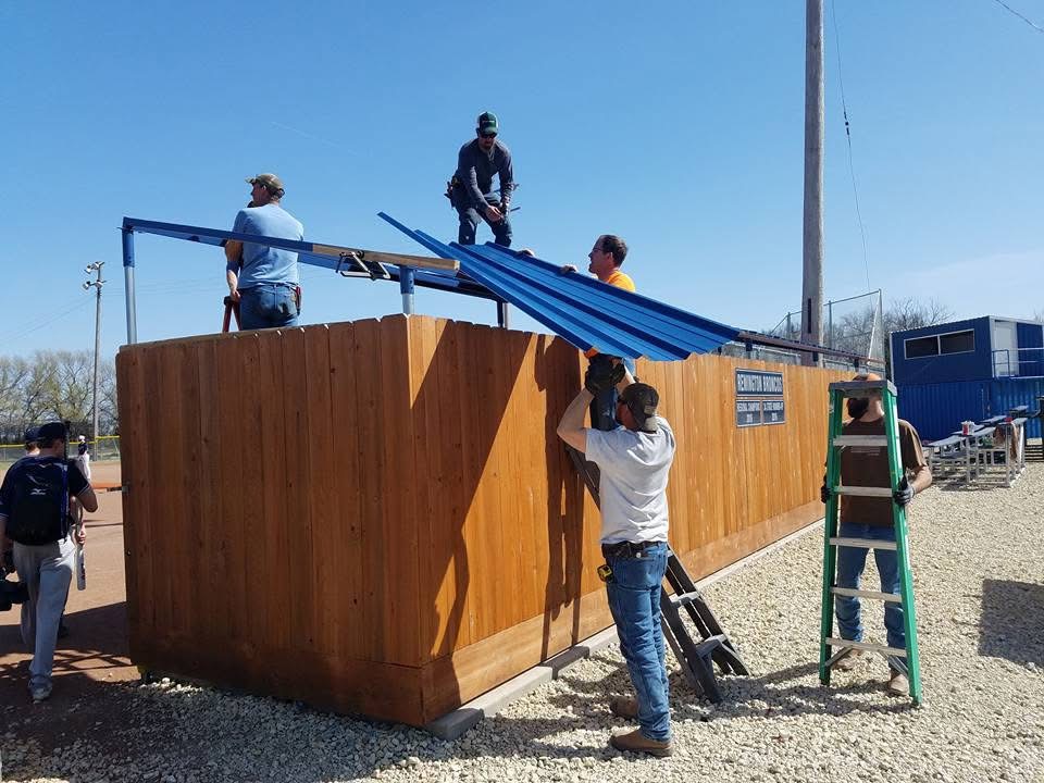men working on installing a dugout