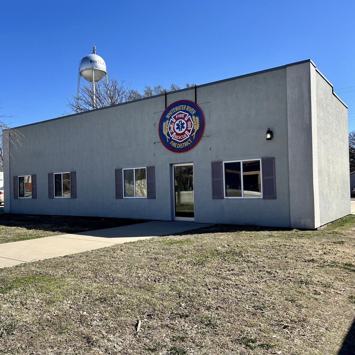 A gray building with a large emblem for the Fire District on the wall
