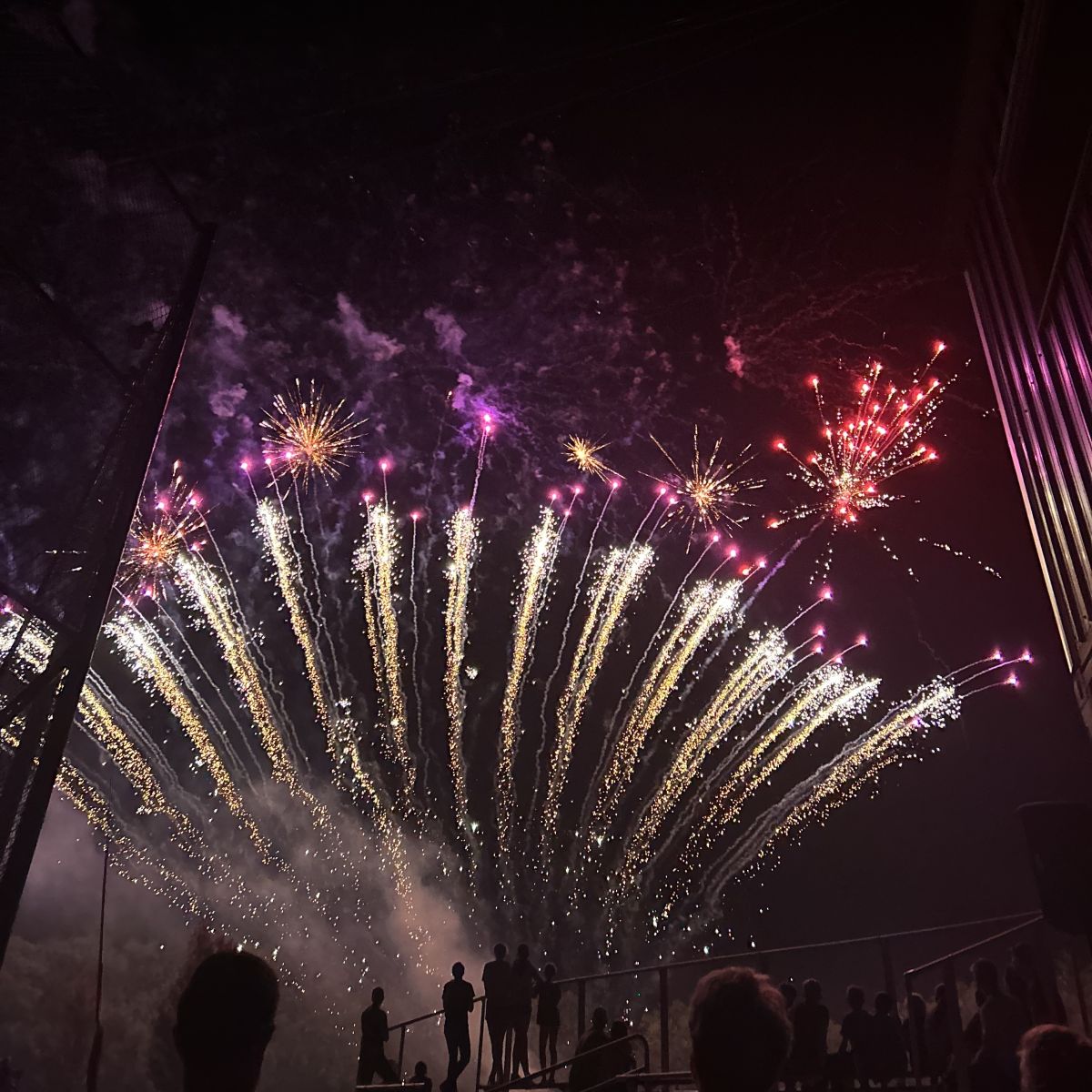 people sihlouetted at the bottom with fireworks sparked overhead