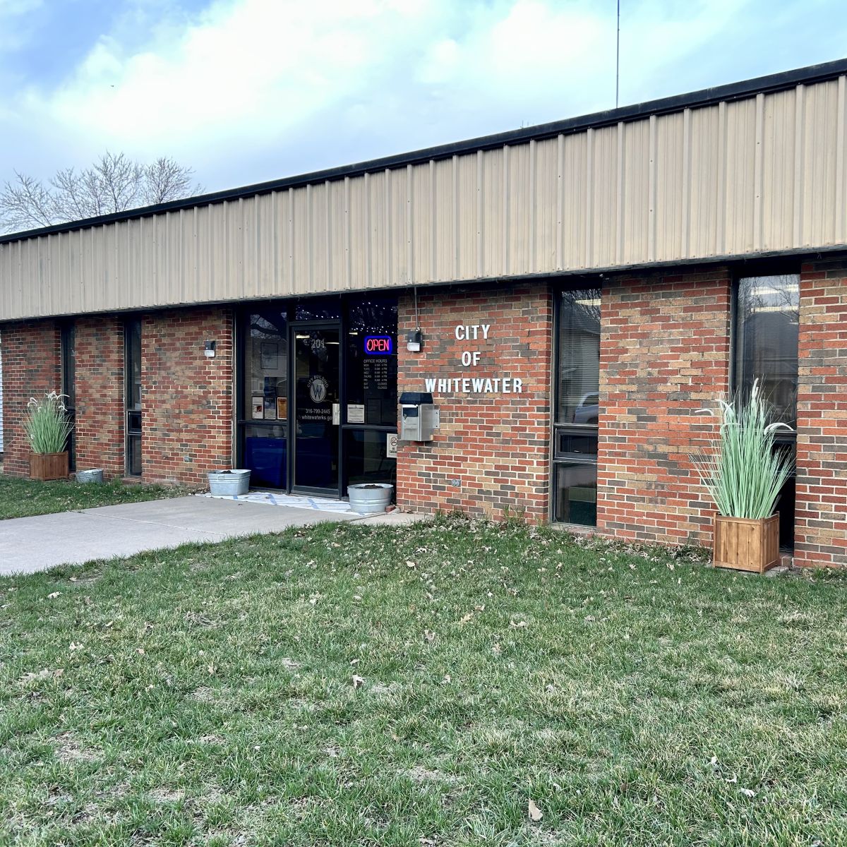 The front doors for the City Building with a walkway and green grass surrounding