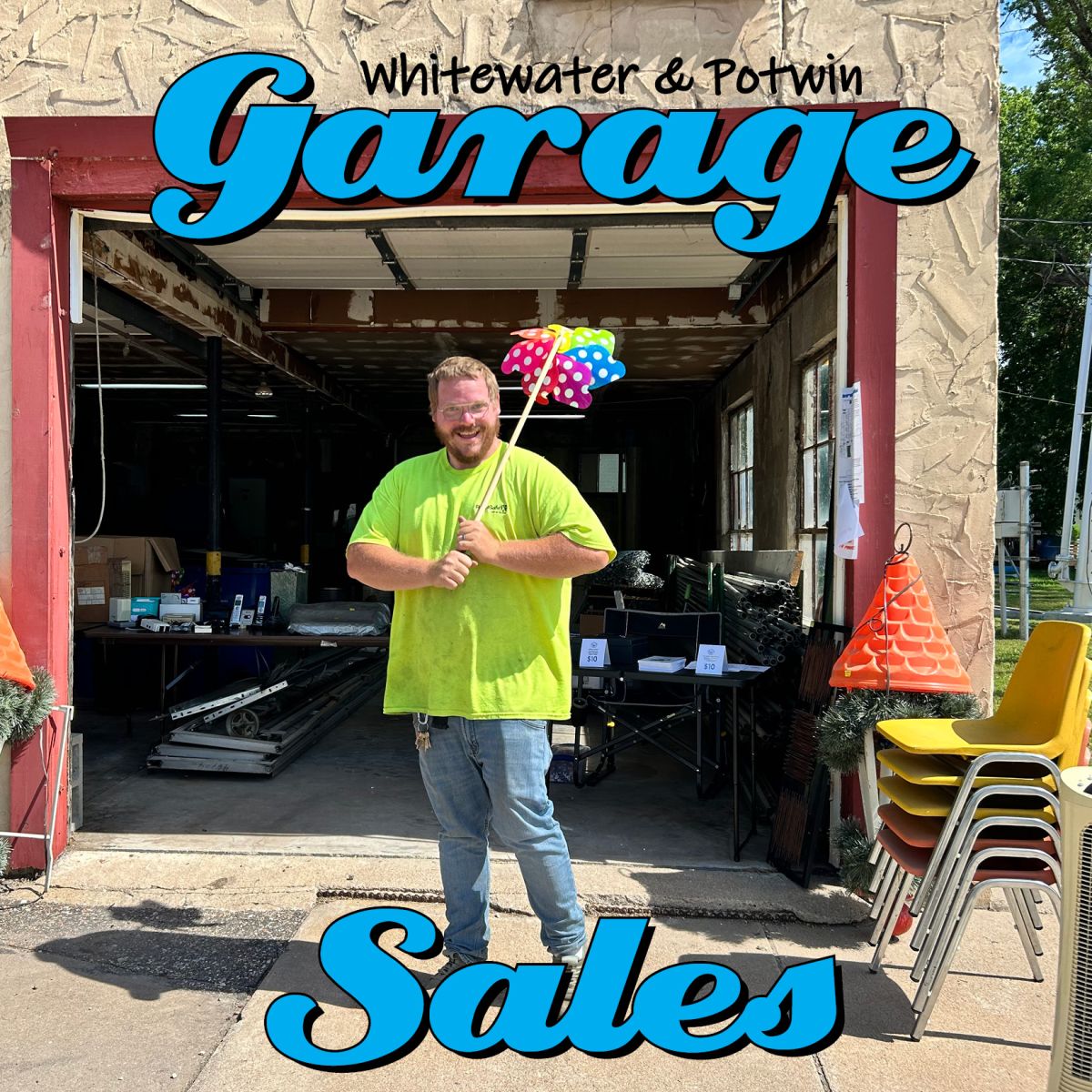 man with a pinwheel standing infront of an open garage with items for sale