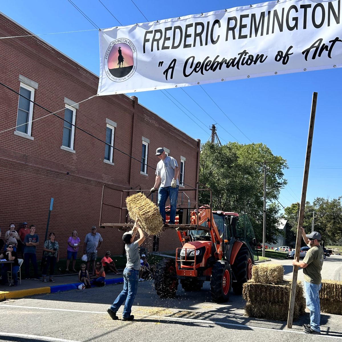 individual throwing a haybale onto a raised platform in competition
