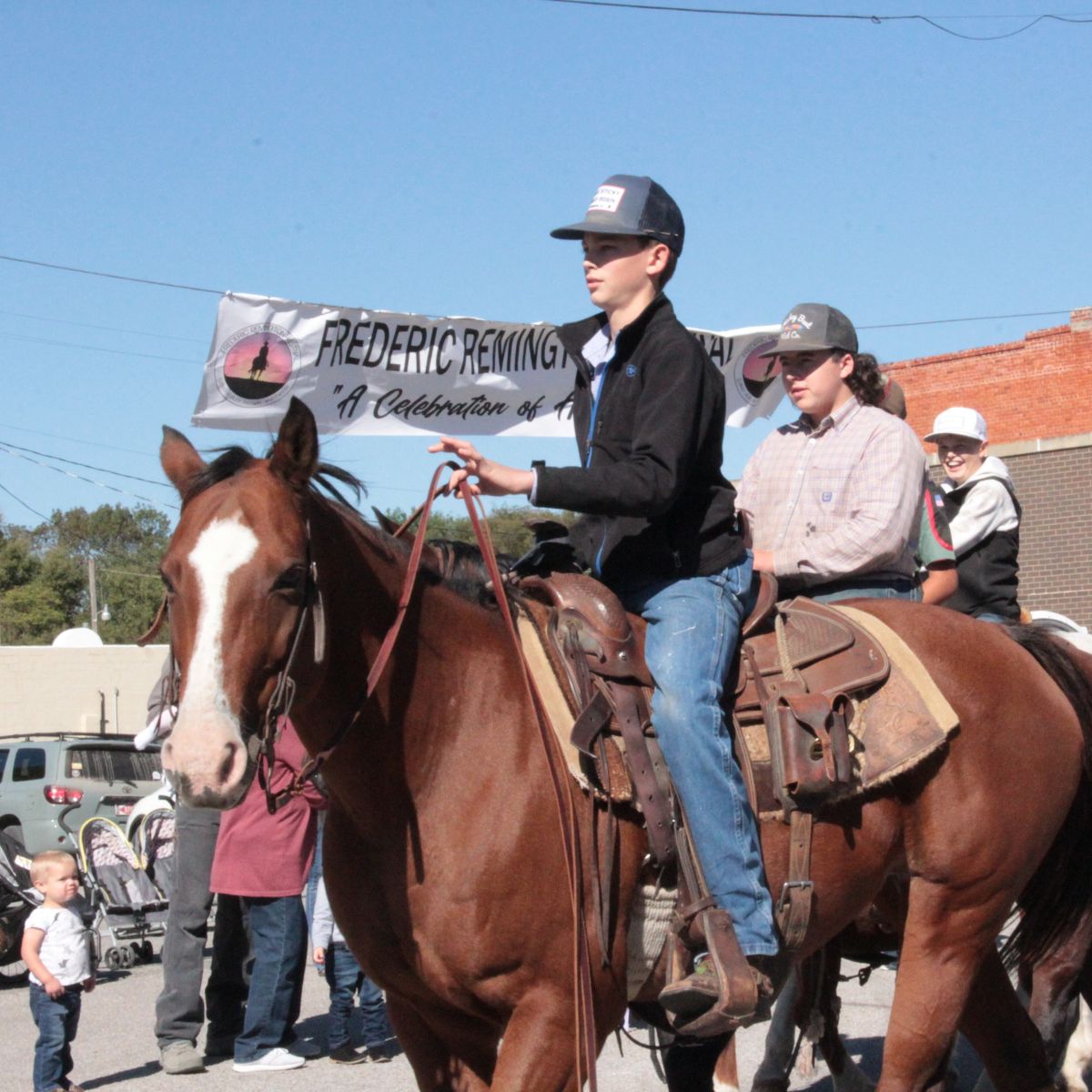 kids riding horse back in parade