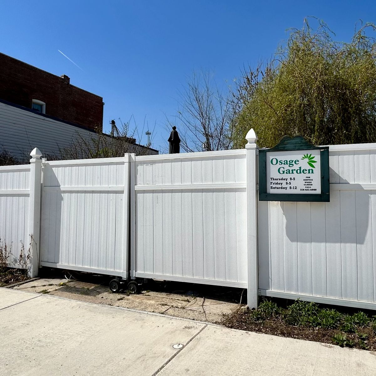 A large White roll away gate and fence for an out door plant and flower shop