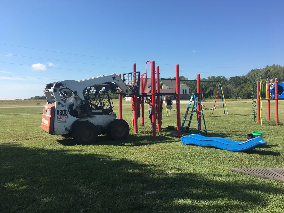 bobcat helping install playground equipment
