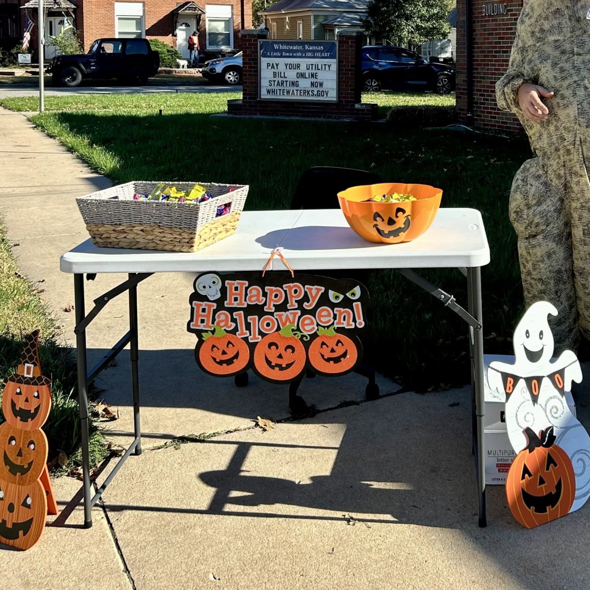 a little table decorated for Halloween with a basket full of candy