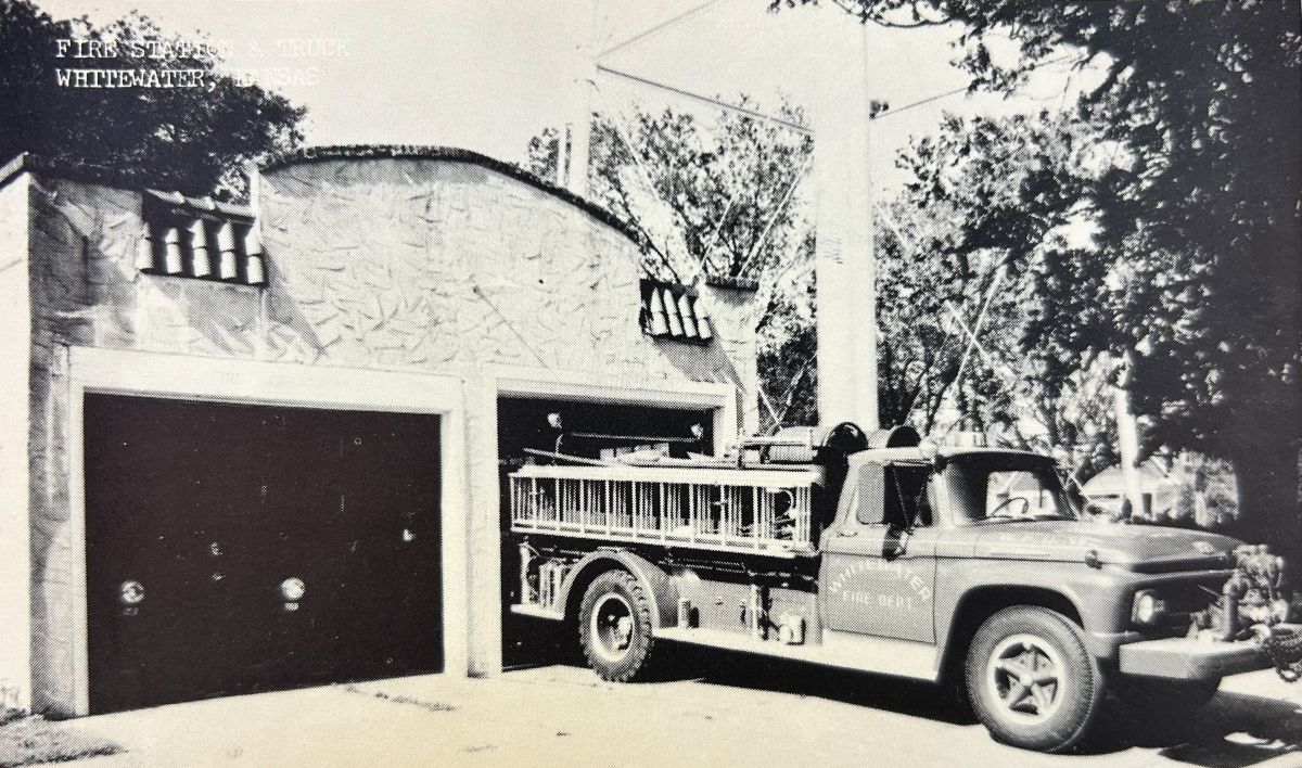 Vintage postcard of an old fire truck in front of an even older fire station