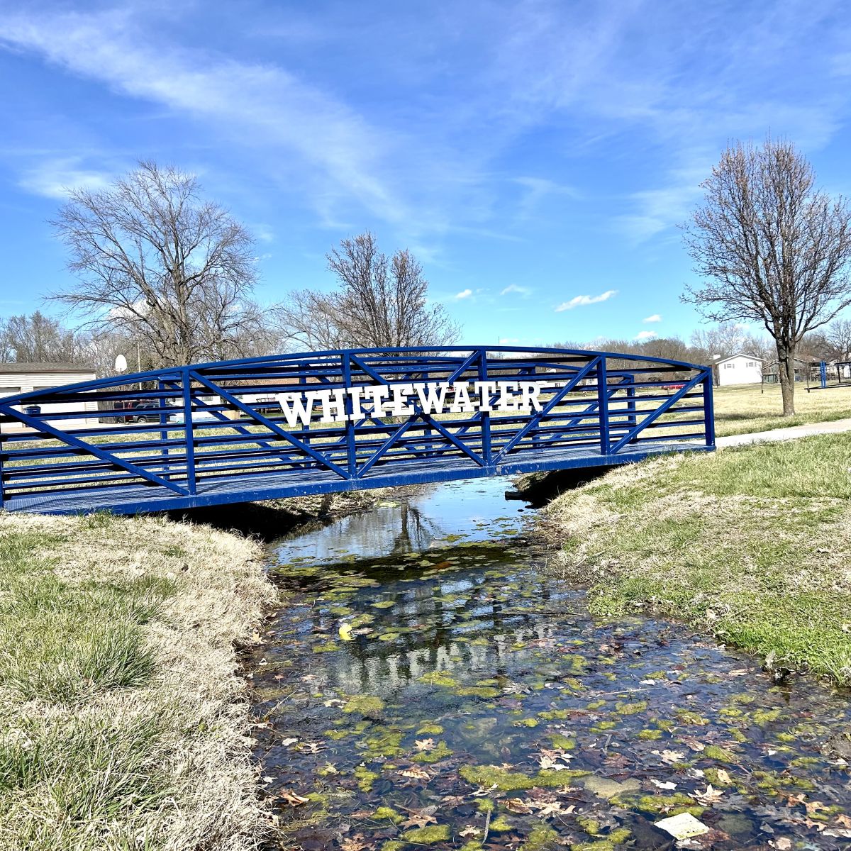 Blue Metal walking bridge over a small stream
