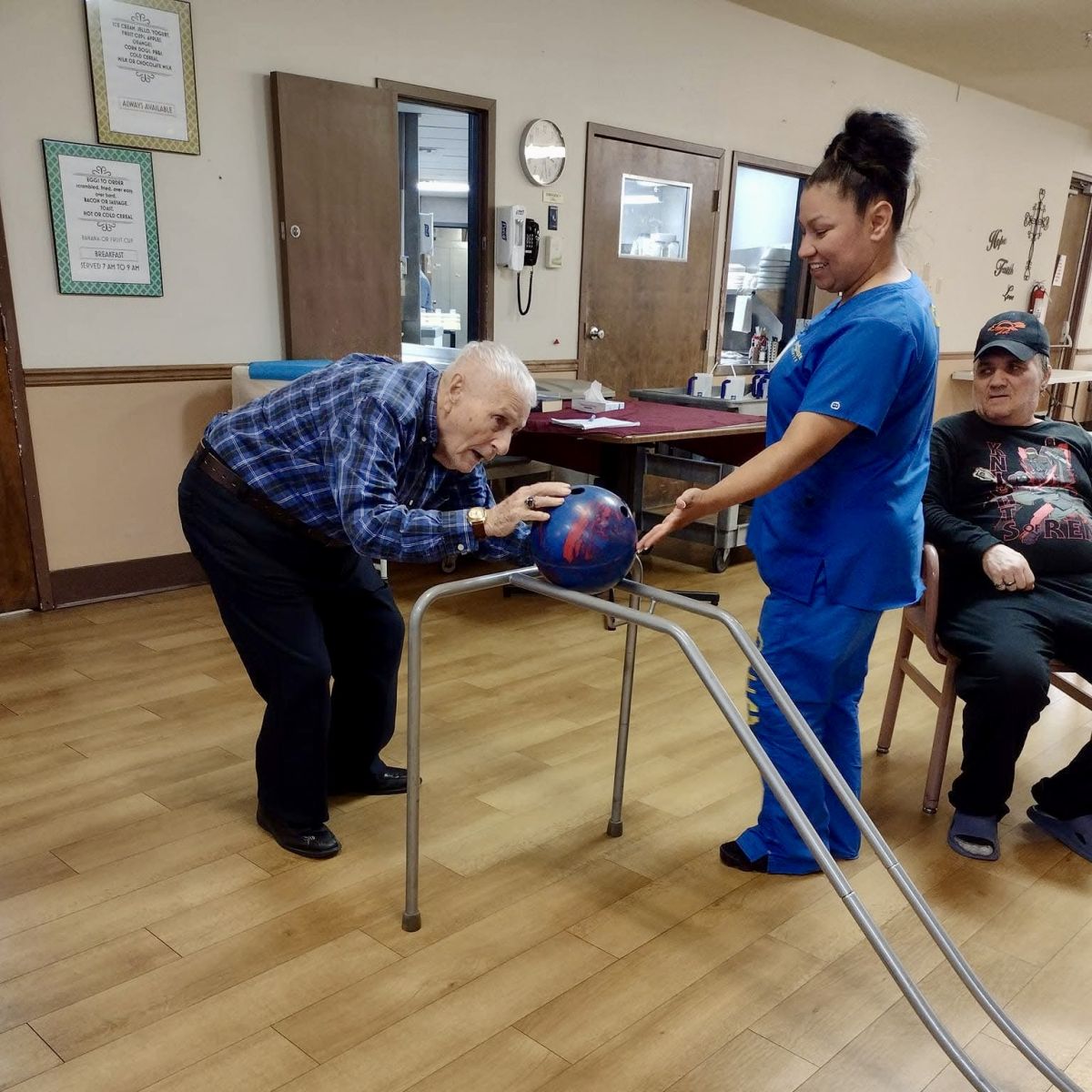 older gentleman bowling with a nurse, therapy
