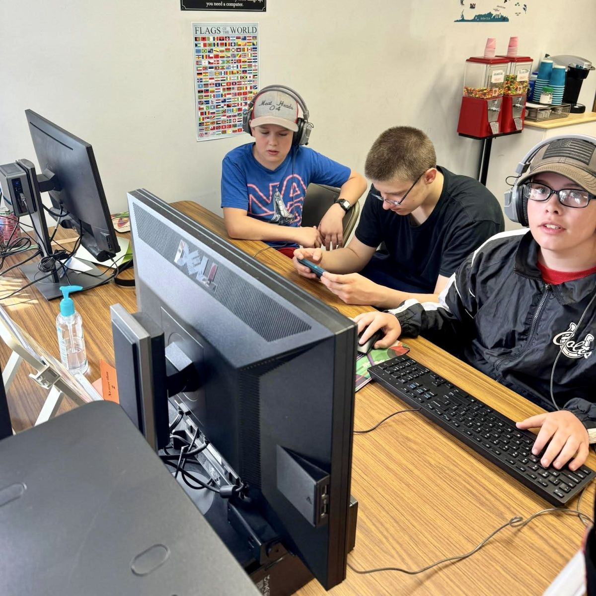 3 boys doing computer work in the library