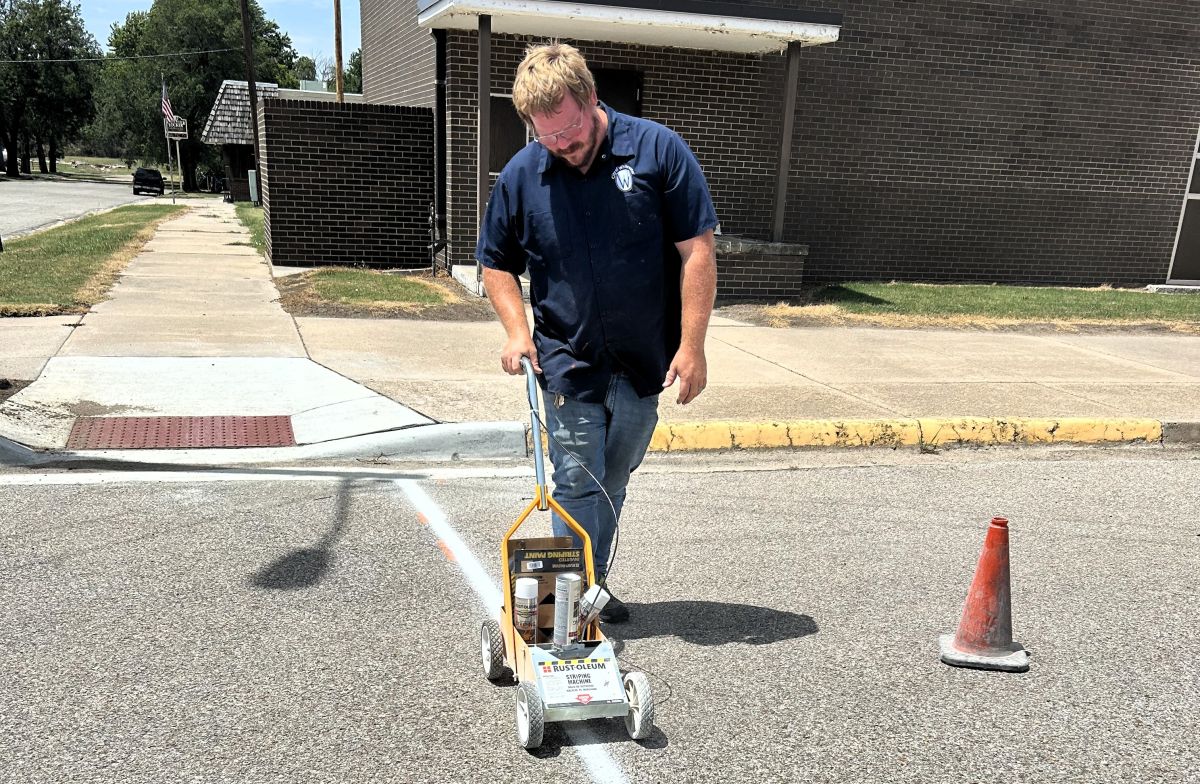 city employee painting a crosswalk