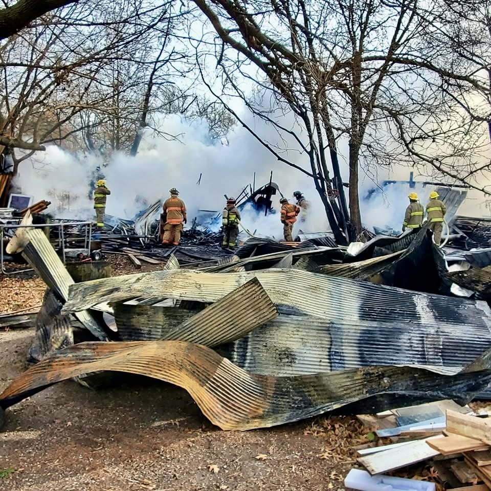 Firefighters working in what remains of a building after a fire