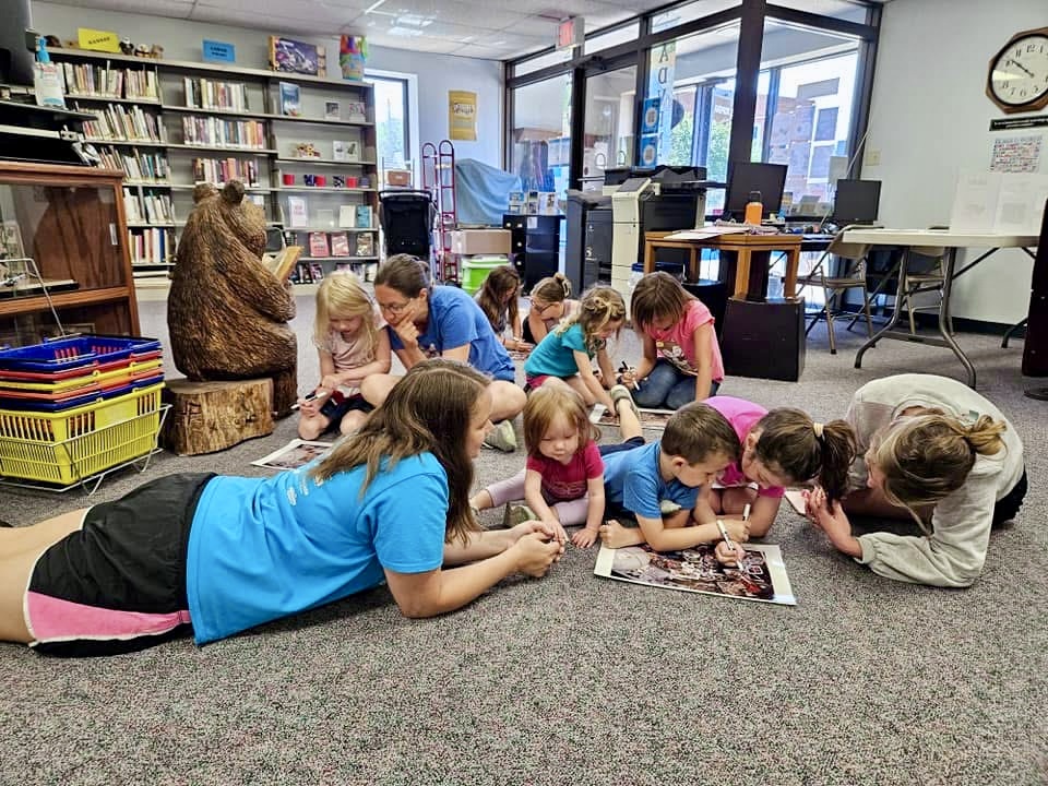 children laying on the floor doing a hidden object activity