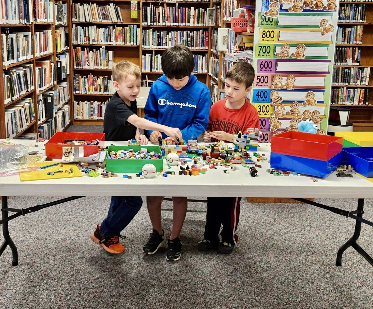 three young boys working at a lego station