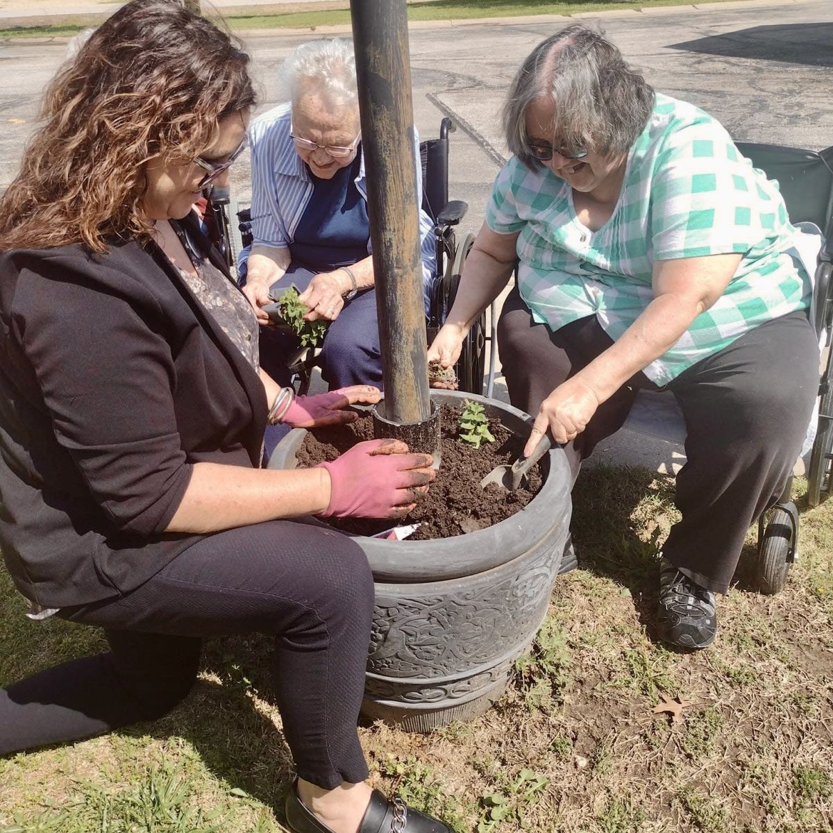 worker and residents planting outside gardens
